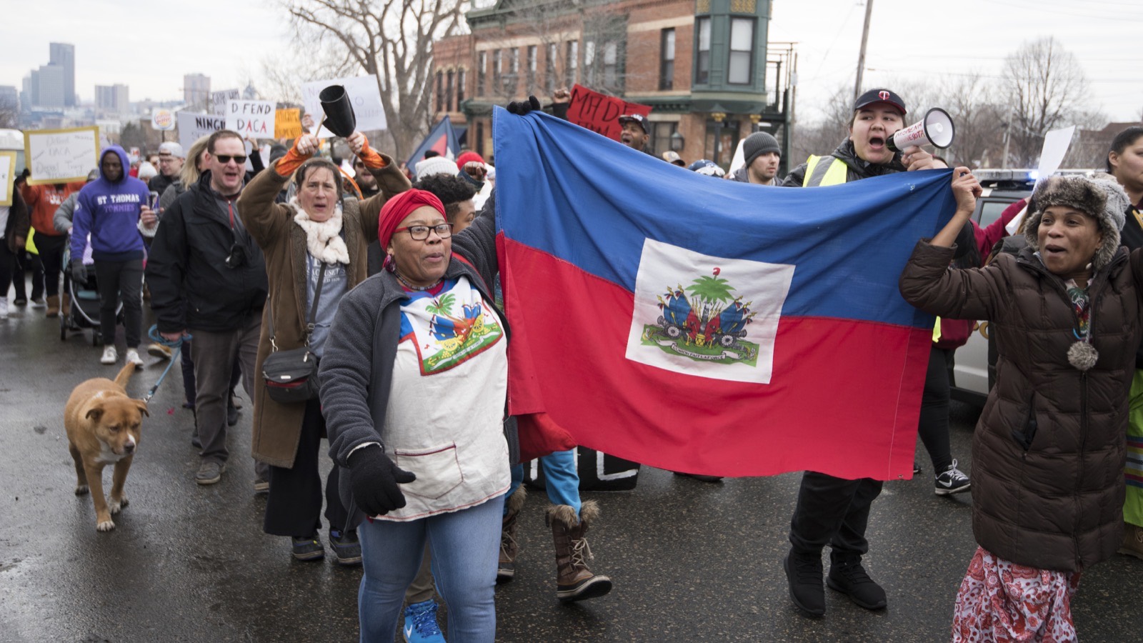 Haitian immigrants marching with Haitian flags at a rally in support of immigrants.