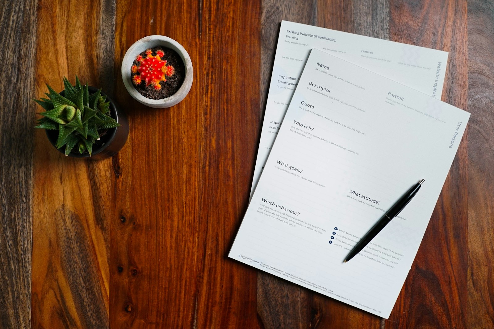 Paperwork and a pen laid out on a wooden desk, organized and ready to review